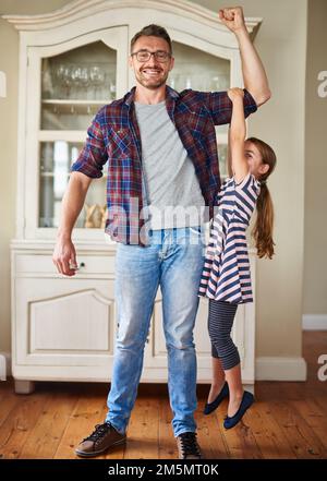 Im un singolo genitore, che cosa è la vostra superpotenza. una bambina che tiene il braccio dei suoi padri mentre la solleva. Foto Stock