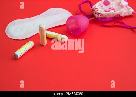 Una collezione di varie opzioni di cura del periodo, tra cui tamponi, tamponi e una coppetta mestruale in silicone, che rappresenta le scelte per la salute femminile, l'igiene, a Foto Stock