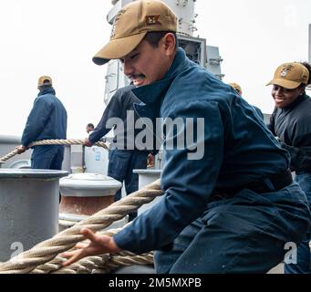 OCEANO PACIFICO (28 marzo 2022) Seaman Greg Lauron, nativo di Los Angeles, assegnato alla nave d'assalto anfibio USS Essex (LHD 2), gestisce la linea durante le operazioni marittime e di ancoraggio a bordo di Essex, 28 marzo 2022. Essex sta conducendo operazioni di routine nella U.S. 3rd Fleet. Foto Stock