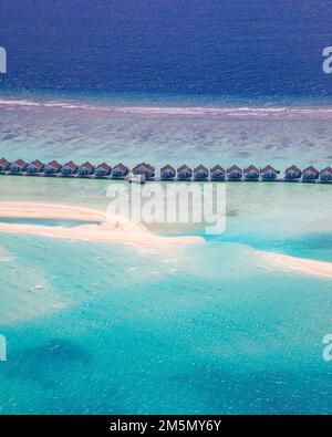 Incredibile atollo e isola alle Maldive dalla vista aerea. Tranquillo paesaggio tropicale e mare con palme su spiaggia di sabbia bianca, natura tranquilla Foto Stock