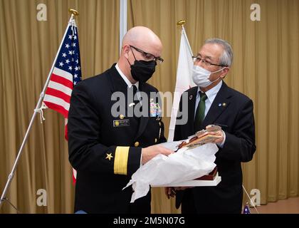 Modulo posteriore Carl Lahti, Commander, Navy Region Giappone/ Commander, USA Forze navali Giappone, riceve un regalo dal sindaco di Saikai Yasuhiko Sugizawa al municipio di Saikai 28 marzo 2022. Lahti ha incontrato i leader della Sasebo City, Saikai City e della forza di autodifesa marittima giapponese nel quadro di una visita programmata al CFAS per acquisire familiarità con l'installazione e l'area locale. Foto Stock