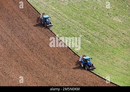 Due trattori raffigurati in agricoltura Goodwood atterrano a Chichester, West Sussex, Regno Unito. Foto Stock