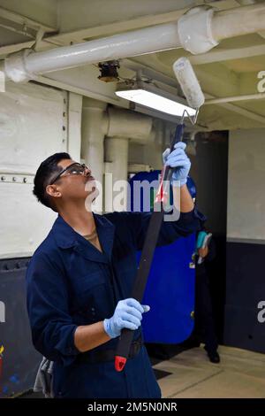 220328-N-TL932-1013 OCEANO PACIFICO (28 marzo 2022) Aviazione Boatswain’s Mate (Handling) Airman Emmanuel Aguilar, nativo di San Diego, California, dipinge la baia dell'hangar a bordo della portaerei di classe Nimitz USS Carl Vinson (CVN 70), marzo 28. Vinson sta attualmente conducendo operazioni marittime di routine nell'Oceano Pacifico. Foto Stock