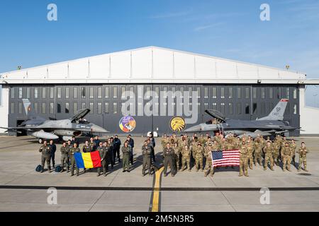 STATI UNITI Air Force Airmen assegnato al 480th Expeditionary Fighter Squadron dalla base aerea di Spangdahlem, Germania, si uniscono insieme con i membri dell'aeronautica rumena di fronte a rumeno e Stati Uniti Air Force F-16 Fighting Falcons per una foto di gruppo 27 marzo 2022, presso 86th Air base, Romania. Da febbraio, l’EFS 480th è stato dispiegato nella AB 86th per migliorare la posizione di difesa collettiva della NATO e sostenere la missione di polizia aerea della NATO. Foto Stock