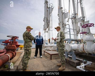 CMdR. Michael Rigoni, direttore del sito del Naval Supply Systems Command (NAVSUP) Fleet Logistics Center (FLC) Yokosuka Site Sasebo parla con l'ADM posteriore Carl Lahti, Comandante, Navy Region Giappone/Comandante, Stati Uniti Forze navali Giappone e Jamie Flett, direttore del sito combustibili di NAVSUP FLC Yokosuka Site Sasebo, durante un tour degli impianti di alimentazione a Commander, Fleet Activities Sasebo (CFAS) 29 marzo 2022. Lahti ha fatto un tour degli impianti di rifornimento di Sasebo FLC Yokosuka Site di NAVSUP e ha incontrato i leader della Sasebo City, Saikai City e della forza di autodifesa marittima giapponese come parte di una visita programmata al CFAS per aumentare la familiarità con il sito di Yokosuka Foto Stock