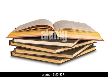 Pila di vecchi libri con copertina rigida con un libro rosso aperto isolato su sfondo bianco con percorso di ritaglio. Foto Stock