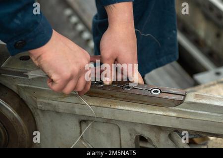 220329-N-SI601-2002 YOKOSUKA, Giappone (29 marzo 2022) Aviation Boatswain’s Mate (Equipment) Airman Michael Maile, di Santa Fe, New Mexico, sostituisce il cavo di sicurezza su una navetta per catapulta a bordo degli Stati Uniti L’unica portaerei della Marina schierata a termine USS Ronald Reagan (CVN 76). Il filo di sicurezza deve essere sostituito periodicamente sulle navette catapulta per mantenere l'integrità della catapulta. Ronald Reagan, il fiore all'occhiello del Carrier Strike Group 5, fornisce una forza pronta per il combattimento che protegge e difende gli Stati Uniti, e sostiene alleanze, partnership e interessi marittimi collettivi Foto Stock