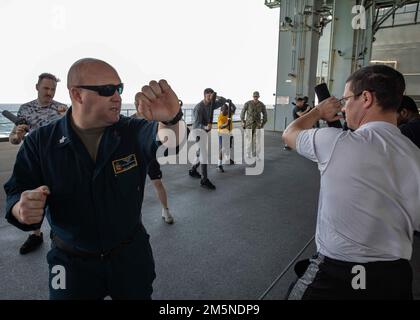 220329-N-TI693-1009 OCEANO ATLANTICO (29 marzo 2022) - Aviation Ordnanceman 1st Classe Matthew Watson, a sinistra, da Skipperville, Alabama, insegna la tecnica di bloccaggio adeguata per danneggiare Controlman 1st Classe Justin Shepard, da Logans Port, Indiana, durante la formazione della forza di reazione di sicurezza a bordo della base marittima Expeditionary USS Hershel 'Woody' Williams (ESB 4), 29 marzo, 2022. Hershel 'Woody' Williams è in fase di implementazione pianificata negli Stati Uniti Sesta area di attività Fleet a sostegno degli interessi nazionali e della sicurezza degli Stati Uniti in Europa e Africa. Foto Stock