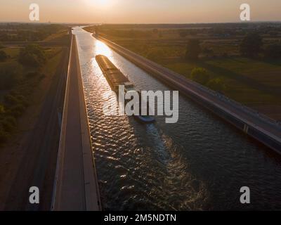 Fucilato, nave da carico al tramonto sul canale Mittelland, raccordo della via navigabile del Magdeburgo, ponte sul canale, canale Mittelland, Elba, Magdeburgo Foto Stock