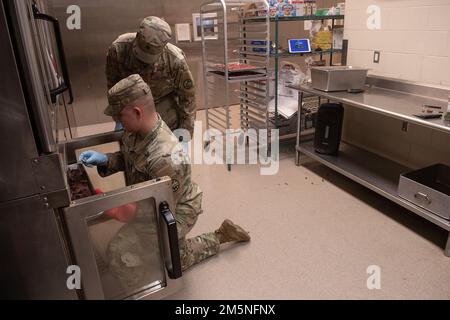 La Guardia Nazionale dell'Idaho PFC. Ethan Mitchell (in ginocchio) e SPC. Jonah Dittenber controllano lo stato di avanzamento della cena. Napoleone Bonaparte viene attribuito come dicendo: “Un esercito marcia sullo stomaco”. Il detto esprime l'importanza che i soldati sul campo non possano essere efficaci se non sono ben nutriti. Il Battaglione di armi combinate della Guardia Nazionale dell'Idaho Army 2-116th è stato sul campo nell'Orchard Combat Training Center negli ultimi giorni di marzo, in preparazione di un imminente dispiegamento a sostegno dell'operazione Spartan Shield. La formazione è stata rigorosa e diversificata. Mentre ogni azienda Foto Stock