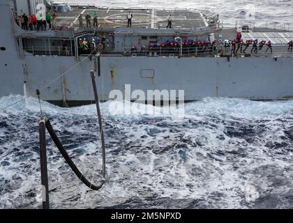 MARE DELLE FILIPPINE (26 febbraio 2022) i marinai a bordo dell'incrociatore missilistico guidato di classe Ticonderoga USS Mobile Bay (CG 53) durante un rifornimento in mare con la portaerei di classe Nimitz USS Abraham Lincoln (CVN 72). Abraham Lincoln Strike Group è in fase di implementazione pianificata nell'area delle operazioni della flotta 7th degli Stati Uniti per migliorare l'interoperabilità attraverso alleanze e partnership e al tempo stesso fungere da forza di risposta pronta a sostegno di una regione indomPacifico libera e aperta. Foto Stock