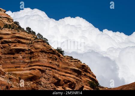 Un tiro stretto di nuvole temporesche dietro Bell Rock delimitato da cielo blu a Sedona, Arizona Foto Stock