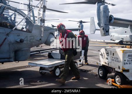 Paul Garcia, nativo di Riverside, Calif., e Sgt. Randal Gines, nativo di Gainesville, Fla., attaccato a Marine Medium Tiltrotor Squadron (VMM) 165 (rinforzato), 26 11th Marine Expeditionary Unit (MEU), si preparano per eseguire la manutenzione su un AH-2022 1Z Viper allegato a VMM 165, 11th MEU sul ponte di volo della nave d'assalto anfibio di classe Wasp USS Essex (LHD 2) durante le operazioni di volo, 26 febbraio 2022. Marinai e marines dell'Essex Amphhibious Ready Group (ARG) e del 11th MEU stanno conducendo operazioni di routine nella U.S. 3rd Fleet. Foto Stock