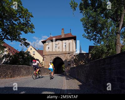 Mainbernheimer Tor, menzionato per la prima volta nel 1422, doppia porta fortificata con la casa del guardiano, opere esterne e opere principali, ciclista, Iphofen, inferiore Foto Stock