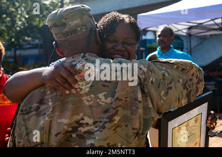 JACKSONVILLE, Florida (26 febbraio 2022) Cynthia Conners, figlia del Mate Sherman Byrd del Capo Maestro Boatswain, Hugs ritirò gli Stati Uniti Frank Davis dopo la presentazione di una risoluzione intitolata in onore del Maestro Chief Byrd durante il Jacksonville Jazz Festival al James Weldon Johnson Park, 26 febbraio 2022. Master Chief Byrd è stato il primo tecnico dell'EOD (Black Explosive Orgnance Disposal) nelle forze armate. Foto Stock