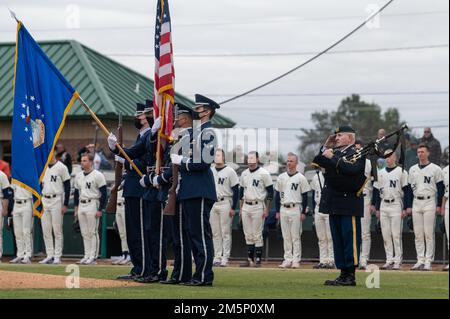 Gli airmen della Guardia d'onore dell'ala combattente 4th salutano durante il canto dell'inno nazionale alla serie annuale di baseball Freedom Classic 12th al Grainger Stadium di Kinston, North Carolina, il 26 febbraio 2022. La Naval Academy ha vinto la serie 2-1 su Air Force Academy. Foto Stock