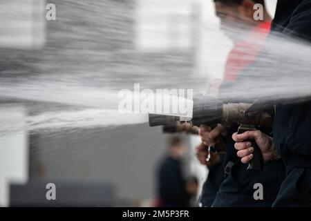 I marinai assegnati al reparto aereo della USS Gerald R. Ford (CVN 78) effettuano test idrostatici sui tubi da fuoco sul ponte di volo, 27 febbraio 2022. Ford è in corso nell'Oceano Atlantico dopo aver completato la parte industriale di una disponibilità incrementale pianificata di sei mesi (PIA). Foto Stock