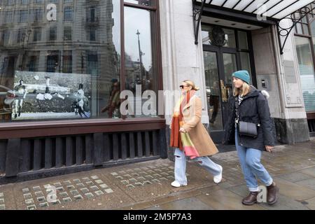 La gente passa davanti a una presentazione di immagini che mostra il calciatore Pele nella finestra dell'Ambasciata brasiliana a Londra in seguito alla morte del tre volte vincitore della Coppa del mondo il giovedì a San Paolo.Data foto: Venerdì 30 dicembre 2022. Foto Stock