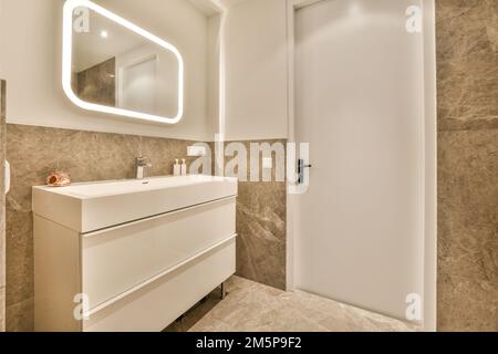 un bagno con uno specchio sopra il lavandino e un armadietto sotto di esso, c'è un portasciugamani sulla parete Foto Stock