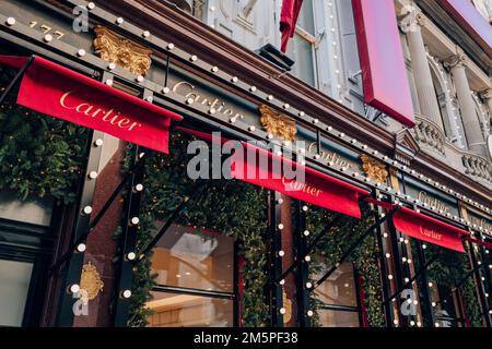 Londra, Regno Unito - 26 dicembre 2022: Decorazioni natalizie sulla facciata del negozio Cartier su New Bond Street, una delle strade più famose per il lusso Foto Stock