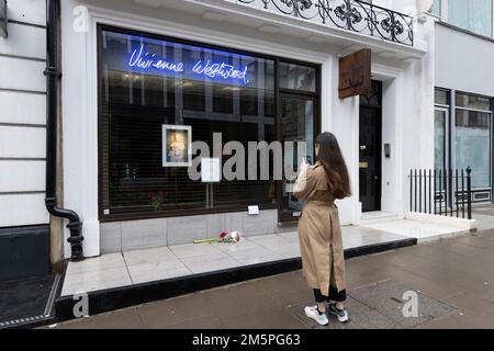 La gente guarda un tributo al negozio di punta Vivienne Westwood a Londra, il fashion designer è morto all'età di 81 anni. Data immagine: Venerdì 30 dicembre 2022. Foto Stock