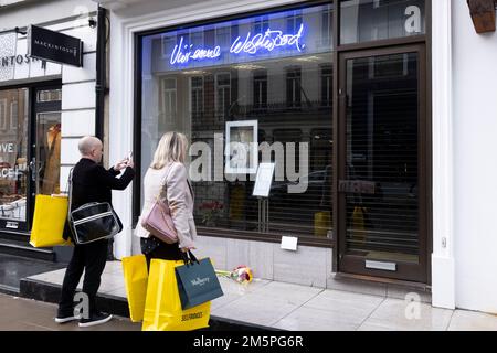 La gente guarda un tributo al negozio di punta Vivienne Westwood a Londra, il fashion designer è morto all'età di 81 anni. Data immagine: Venerdì 30 dicembre 2022. Foto Stock