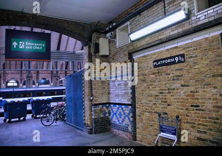 Piattaforma 9 e 3/4 alla stazione ferroviaria di King's Cross, con un carrello per bagagli che passa attraverso il muro, come nelle storie di Harry Potter Foto Stock