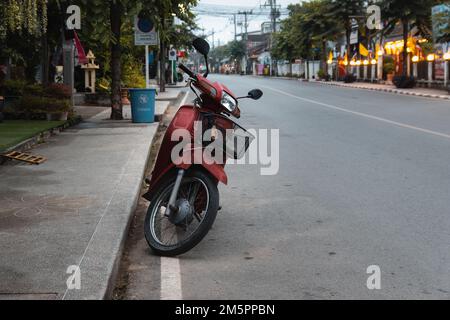 PAI, Thailandia. Novembre 19, 2022. Moto rosso parcheggiato sulla strada a Pai Foto Stock