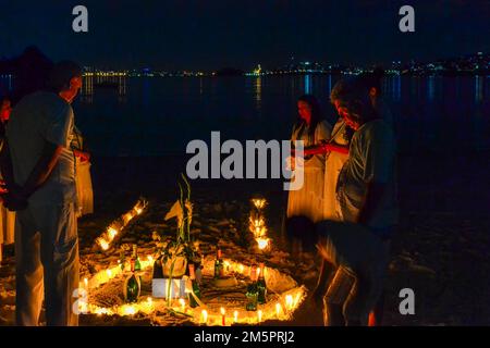 Religione Umbanda. Un gruppo di persone tiene una veglia a lume di candela sulla spiaggia di San Francisco. Umbanda è una religione sincretica afro-brasiliana. Foto Stock