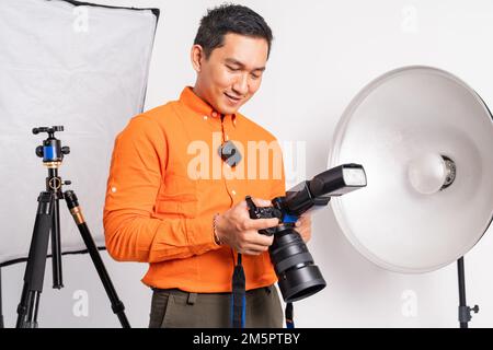 primo piano di vlogger uomo in piedi impostazione fotocamera in isolato Foto Stock