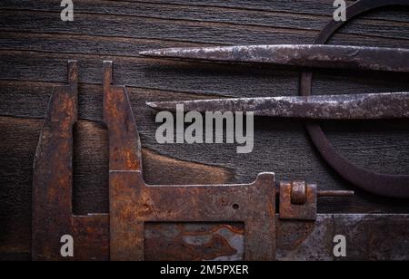 Set di calibri a nonio arrugginiti su fondo in legno vintage. Foto Stock