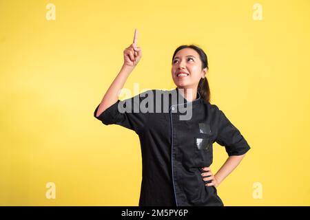 chef femminile asiatico eccitato con dito verso l'alto Foto Stock