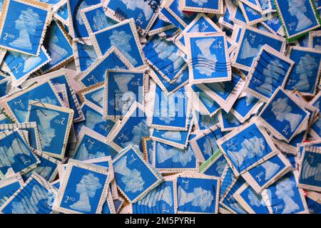 Usato UK franked francobolli di affrancatura che sono collectd per un contributo di carità. Una selezione colorata di francobolli di uso Royal Mail britannici in primo piano. Regno Unito. Francobolli blu di seconda classe (2nd ) Foto Stock