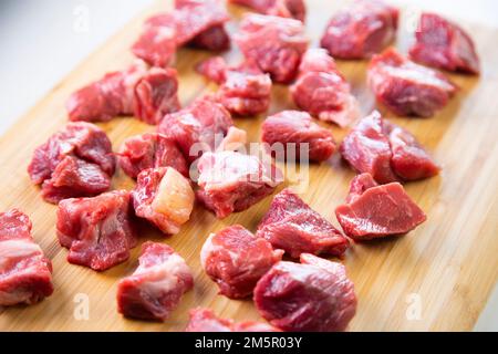 Carne di prima qualità si incontrano in diversi tagli su un tavolo di legno. Foto Stock