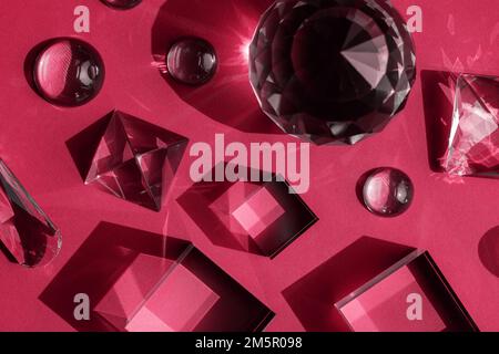 Colore dell'anno 2023 Viva magenta. Prisma di cristallo luce rifrangente, cristalli magici e piramide, sfera e cubo su sfondo viola. Spirituale Foto Stock