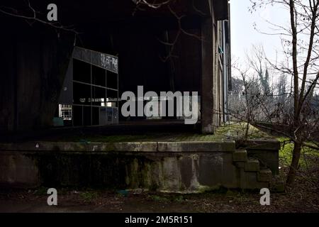 Ingresso di un magazzino abbandonato in un parco in una giornata nuvolosa Foto Stock