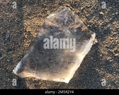 Ghiaccio su un'immagine di concetto della spiaggia che riflette le edizioni come il cambiamento di clima, gli eventi estremi di tempo o le idee come i contrasti (caldo contro freddo, estate contro inverno). Foto Stock