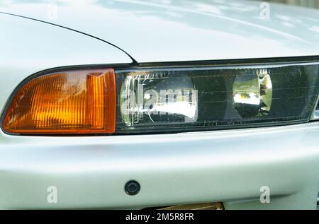 Bobruisk, Bielorussia, 22 luglio 2022: Un frammento di una macchina Mitsubishi Galant, vista frontale dei fari. Foto Stock