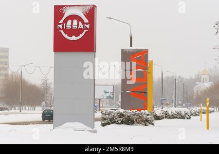 Bobruisk, Bielorussia, 17 dicembre 2022: Nissan Motor Corporation e Lada cartelloni vicino agli showroom di automobili Foto Stock