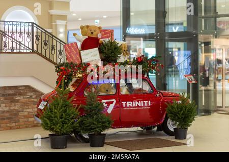 Grodno, Bielorussia - 11 dicembre 2022: Auto retrò decorato con luci festive di Capodanno, ghirlande, rami di alberi di Natale, scatole da regalo in multivalor Foto Stock