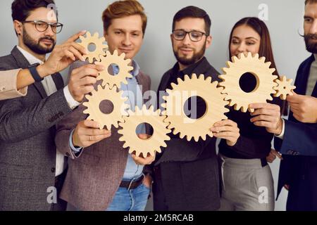 Gruppo di uomini d'affari che collegano le ruote dentate in legno insieme Foto Stock