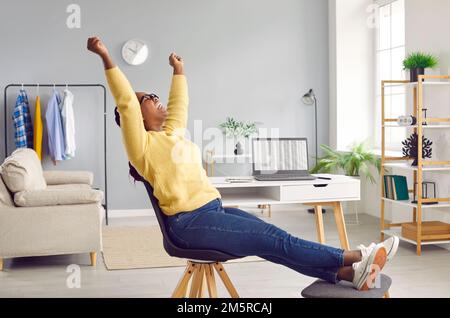 Donna felice ed eccitata alzando le mani e gridando con gioia che festeggia il commercio in linea riuscito. Foto Stock