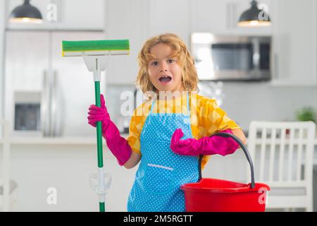 Un bambino carino aiuta nella pulizia della casa vicino spazzare la  spazzatura con una scopa per bambini dal pavimento in una casseruola  giocattolo Foto stock - Alamy