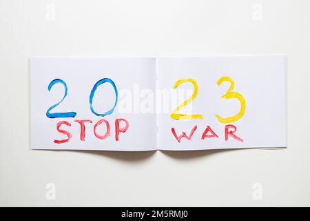 2023 è dipinto con colori giallo e blu nel colore della bandiera dell'Ucraina su un album bianco su sfondo bianco e il testo STOP War, Happy NE Foto Stock