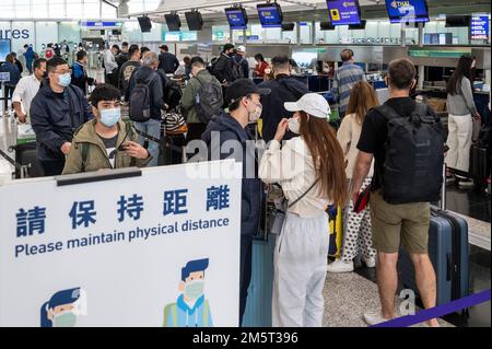 Hong Kong, Cina. 29th Dec, 2022. I passeggeri attendono in fila il banco del check-in della Thai Airways come un cartello ricorda alle persone di mantenere le distanze sociali nell'Aeroporto Internazionale Chek Lap Kok di Hong Kong. I visitatori di Hong Kong non avrebbero più bisogno di sottoporsi al periodo di sorveglianza medica ''0 3'' (Covid-19) dopo che il governo ha posto fine alle restrizioni sui viaggi. (Credit Image: © Miguel candela/SOPA Images via ZUMA Press Wire) Foto Stock