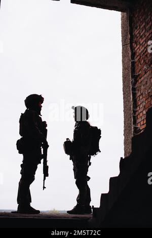 Silhouette foto del militare ucraino. Fratelli in armi, un uomo e una donna con armi in mano. Foto Stock