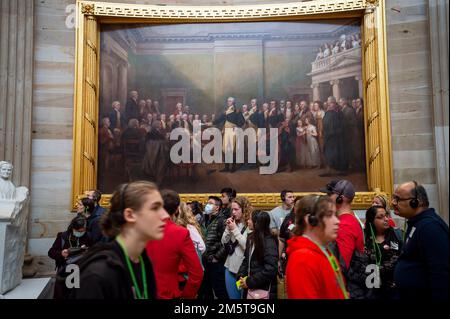 Washington DC, Stati Uniti. 30th Dec, 2022. I turisti si trovano sotto un dipinto di George Washington che dimetterà la sua âGeneral Commissionâ nella US Capitol Rotunda. 19 persone in questo dipinto sono state identificate come schiavi. Dipinti di momenti importanti nella storia degli Stati Uniti e sculture di figure storiche sono in mostra, pagando tribuna a schiavi e confederati al Campidoglio degli Stati Uniti a Washington, DC, Venerdì 30 dicembre 2022. Credit: Rod Lamkey / CNP Credit: dpa picture Alliance/Alamy Live News Foto Stock