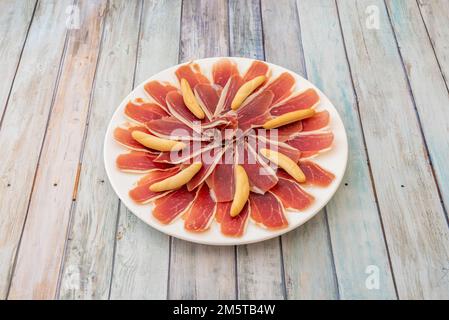 Ottima porzione di prosciutto iberico con crostini, una delle tapas più tipiche dei bar spagnoli Foto Stock