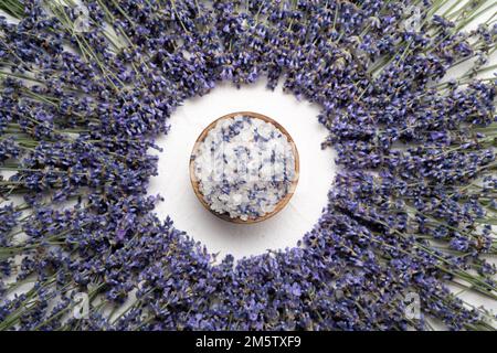 Lavanda naturale, sale su fondo di cemento bianco, articoli igienici per il bagno e la spa. Piano di giacitura, vista dall'alto. Spazio di copia Foto Stock