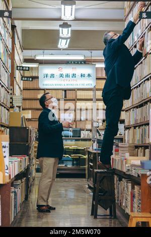 Un addetto alle vendite della libreria che si occupi di un cliente Foto Stock